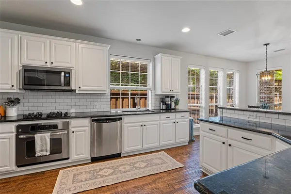 a kitchen with stainless steel appliances granite countertop a stove and a sink