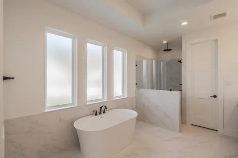 a bathroom with a bathtub a sink and a window