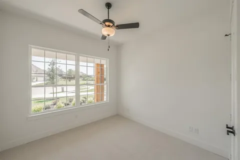 an empty room with a window and a fan