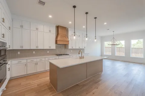 a large kitchen with stainless steel appliances kitchen island a cabinets and wooden floor