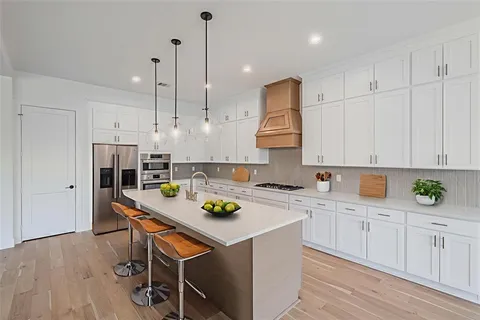 a kitchen with white cabinets and appliances