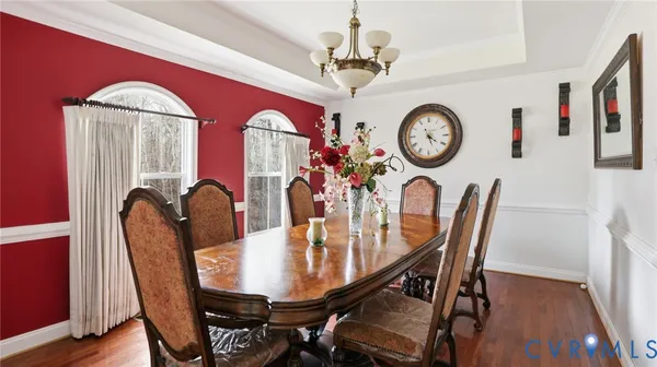 a view of a dining room with furniture a rug and wooden floor