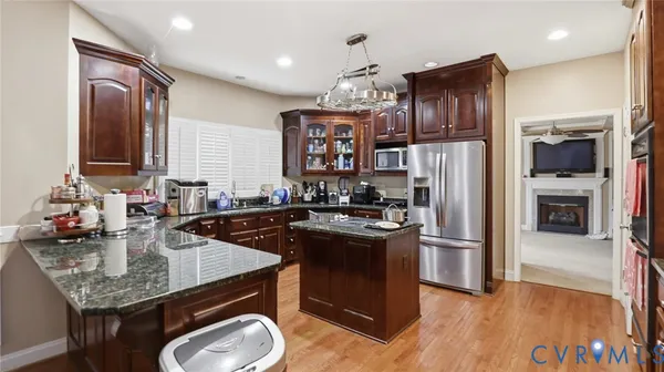 a kitchen with stainless steel appliances granite countertop a sink refrigerator and cabinets