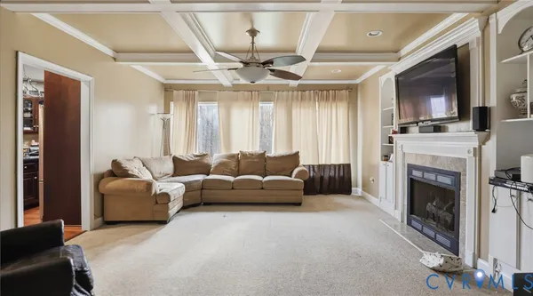 a living room with furniture a fireplace and a flat screen tv