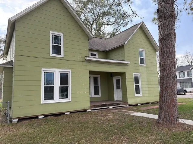 a front view of a house with a tree