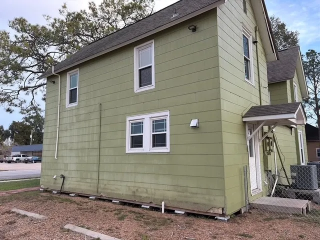 a view of a house with a yard and wooden fence