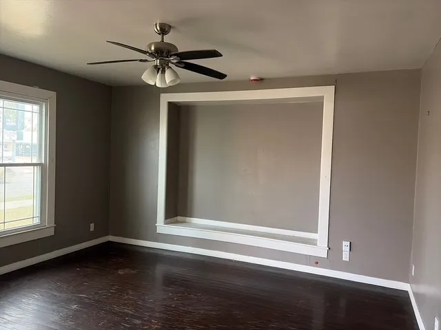 a view of a livingroom with a ceiling fan and wooden floor