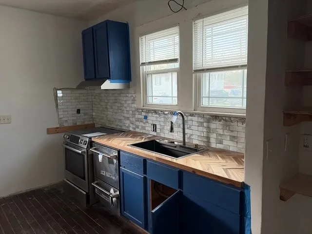 a kitchen with a sink stove and cabinets