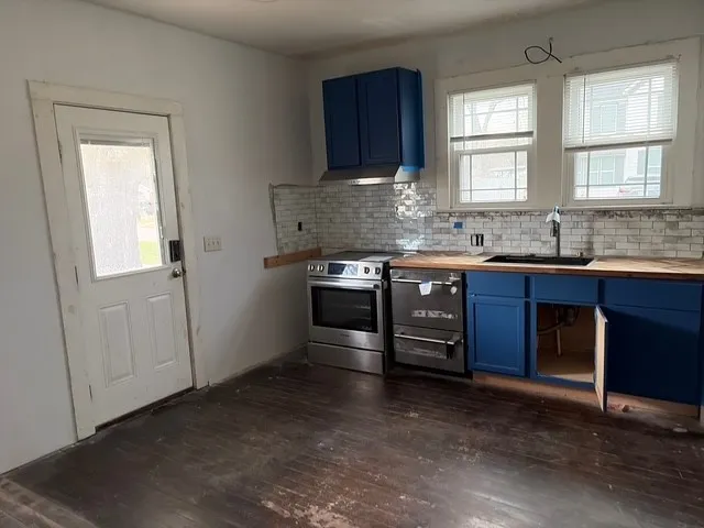 a kitchen with stainless steel appliances granite countertop a sink stove and cabinets