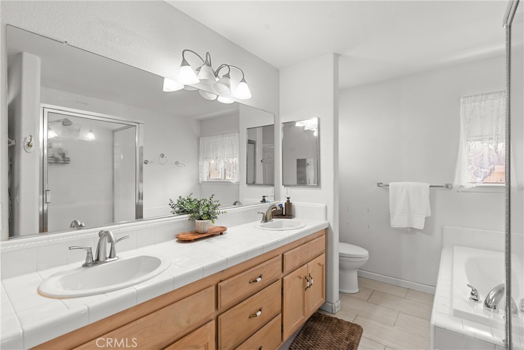 781 Koval Lane Santa Maria, CA 93455 - Photo 27 of 33 a bathroom with a double vanity sink a toilet and a mirror