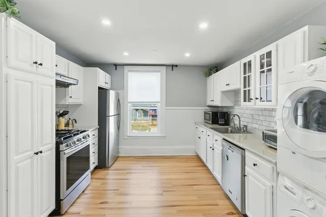 a kitchen with stainless steel appliances a refrigerator sink and cabinets