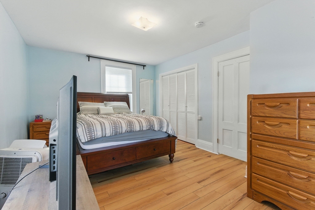 35 Locust Street, Unit 3 Danvers, MA 01923 - Photo 41 of 42 a bedroom with a bed and wooden floor