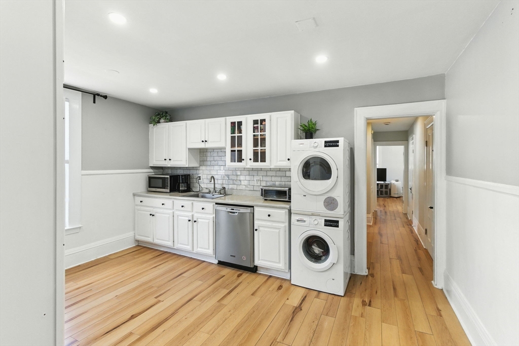 35 Locust Street, Unit 3 Danvers, MA 01923 - Photo 6 of 42 a kitchen with stainless steel appliances granite countertop a stove and white cabinets
