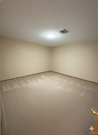 a view of an empty room with window and chandelier