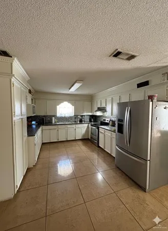 a view of kitchen with furniture and refrigerator