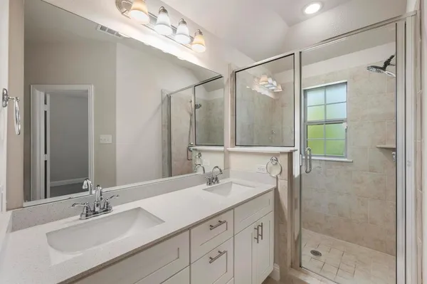 a bathroom with a shower sink and mirror