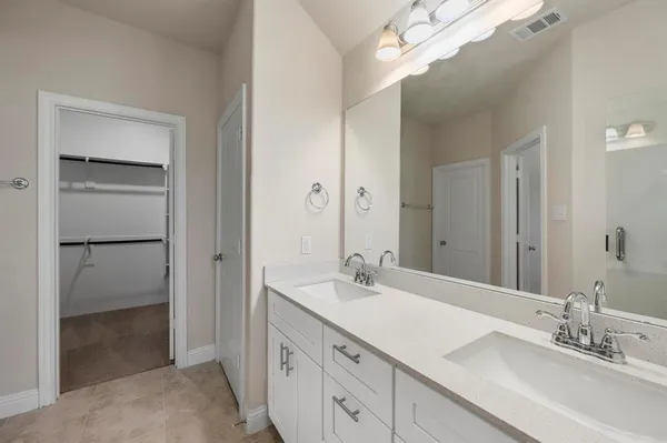 a bathroom with a double vanity sink a mirror and a shower