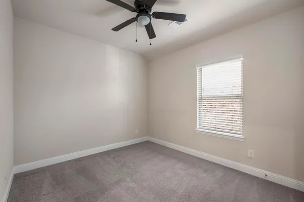 an empty room with a window and a fan