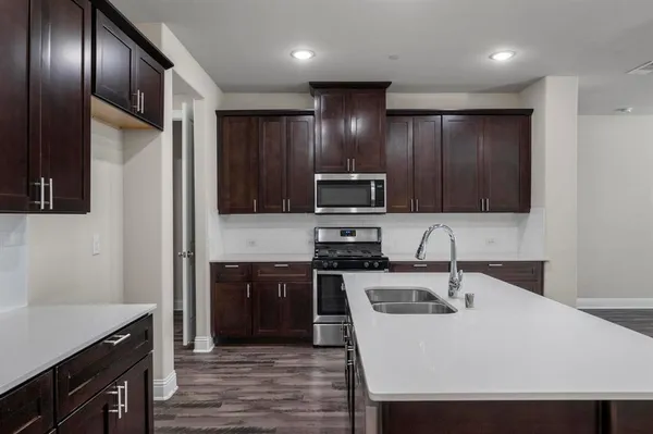 a kitchen with stainless steel appliances wooden cabinets a sink and a stove