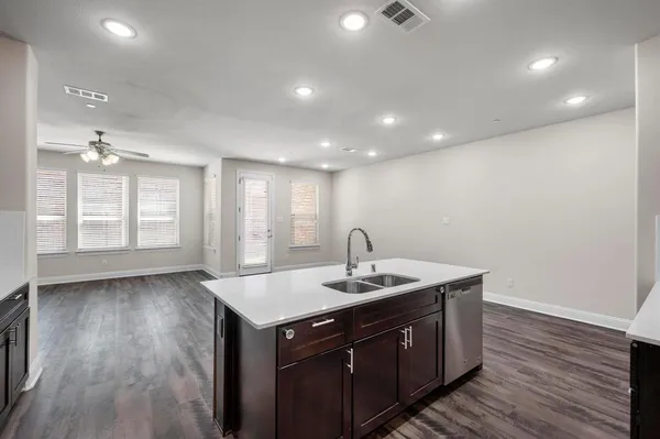 a kitchen with a sink cabinets and wooden floor