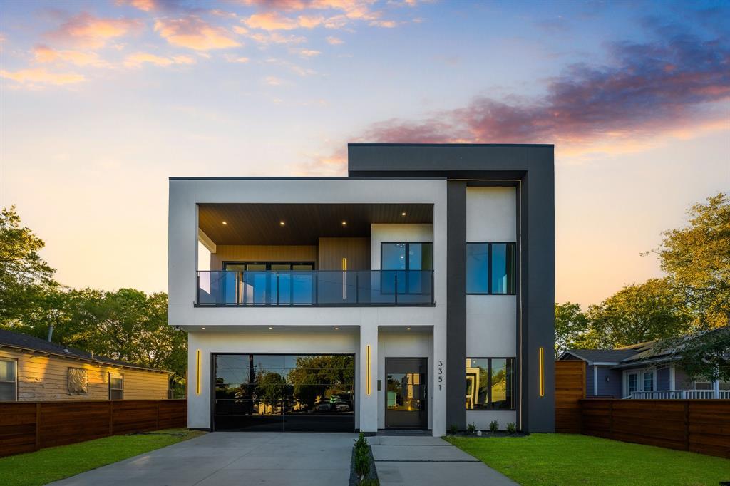 Modern custom built home with front driveway, stucco siding and a glass door garage