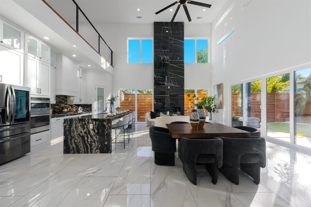 3351 Sylvan Avenue Dallas, TX 75212 - Photo 11 of 40 a dining hall with stainless steel appliances kitchen island granite countertop a table chairs and a refrigerator