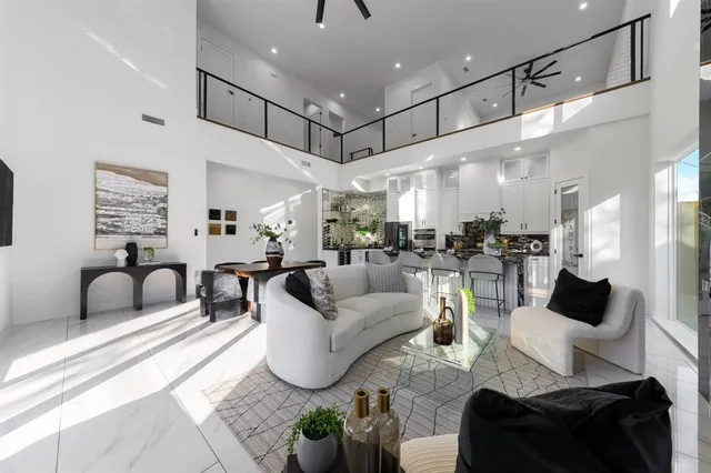 a living room with furniture kitchen view and a chandelier