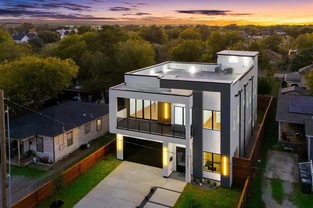 a view of a big house with a big yard plants and large tree
