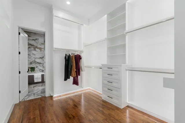 a view of walk in closet with clothes and shoes
