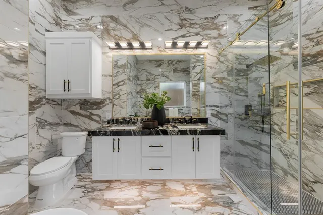 a bathroom with a sink a toilet and shower