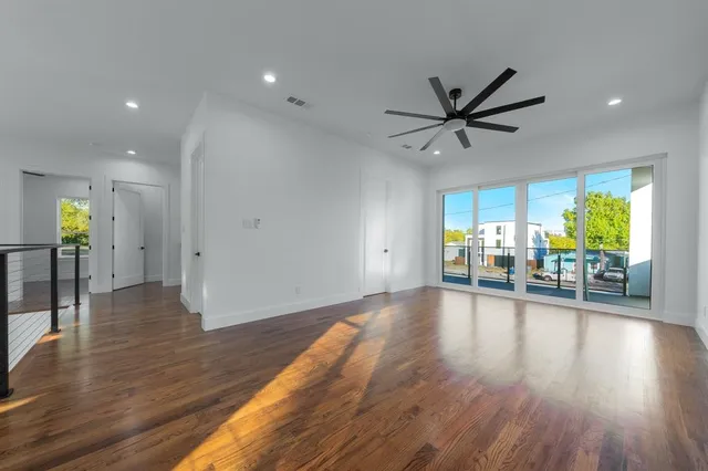 a view of empty room with wooden floor and a ceiling fan