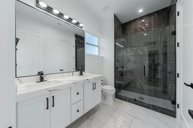 a bathroom with a double vanity sink mirror and shower