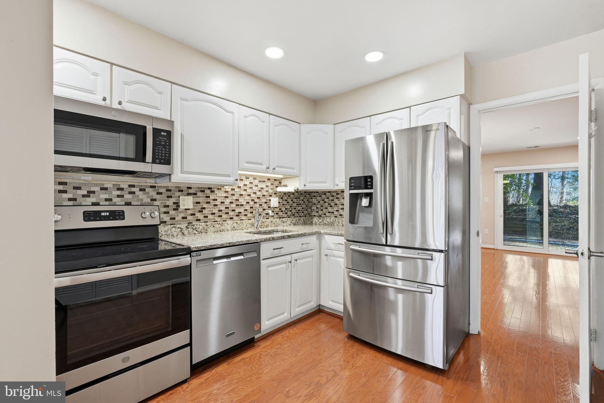 1942 Winterport Cl Reston, VA 20191 - Photo 6 of 19 a kitchen with granite countertop stainless steel appliances and wooden cabinets