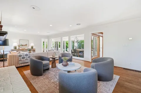 a living room with furniture a rug and a large window