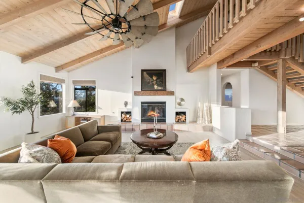 a living room with furniture a chandelier and a rug