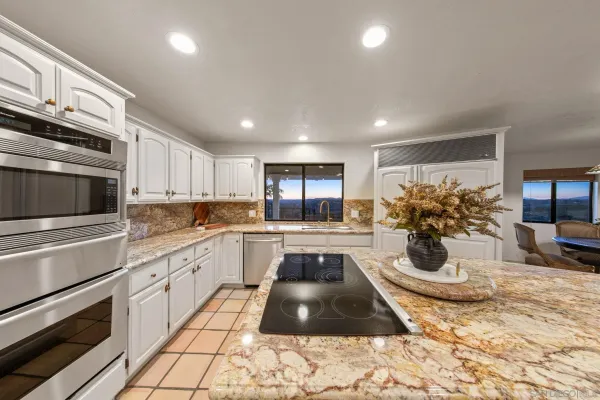 a kitchen with stainless steel appliances granite countertop a sink and a wooden cabinets