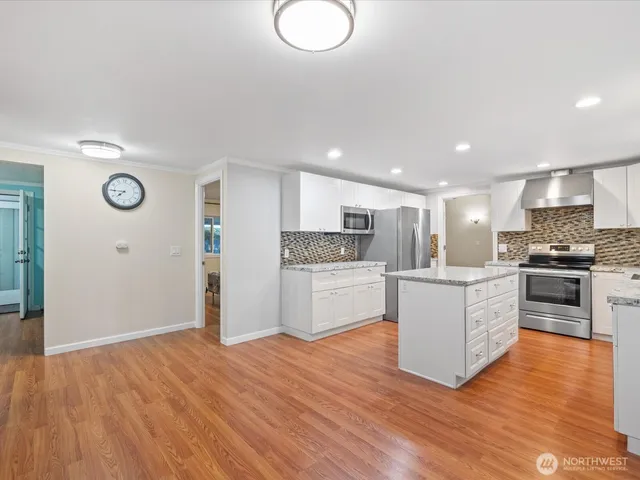 a kitchen with granite countertop a stove top oven and cabinets