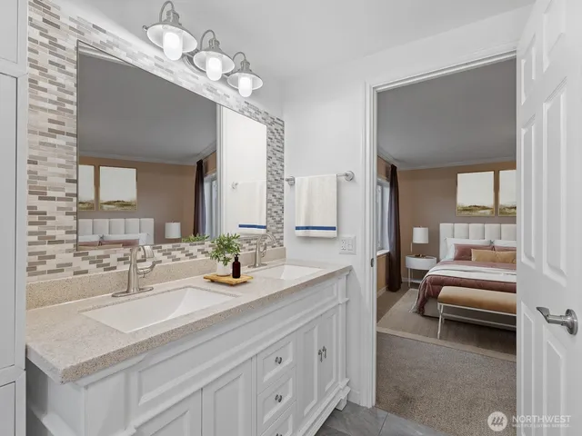 a spacious en suite bathroom with a double vanity sink and a mirror