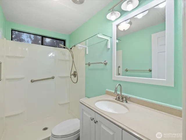 a bathroom with a sink a toilet and shower