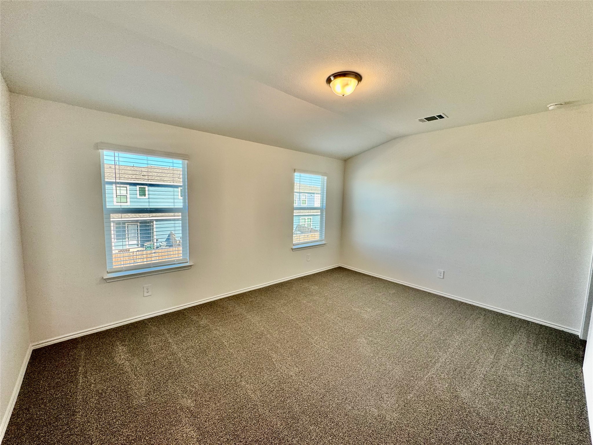 105 Calcite Road, Unit 2 Kyle, TX 78640 - Photo 4 of 7 Carpeted spare room with lofted ceiling and a textured ceiling