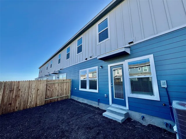 a view of a house with wooden fence and a stairs