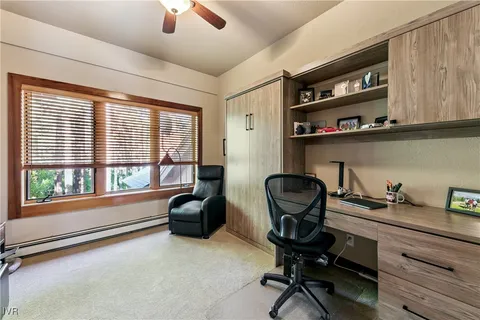 a view of a workspace with furniture and a window
