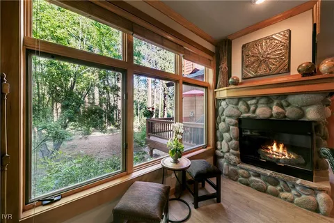 a living room with furniture a fireplace and a floor to ceiling windows