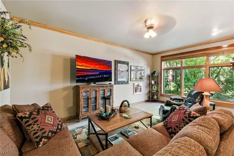 a living room with furniture a flat screen tv and a large window