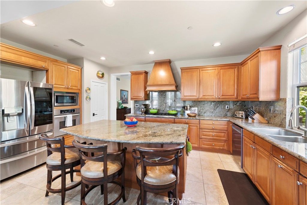 15 Corte Limonada San Clemente, CA 92673 - Photo 22 of 64 a kitchen with stainless steel appliances granite countertop a table chairs sink refrigerator and cabinets