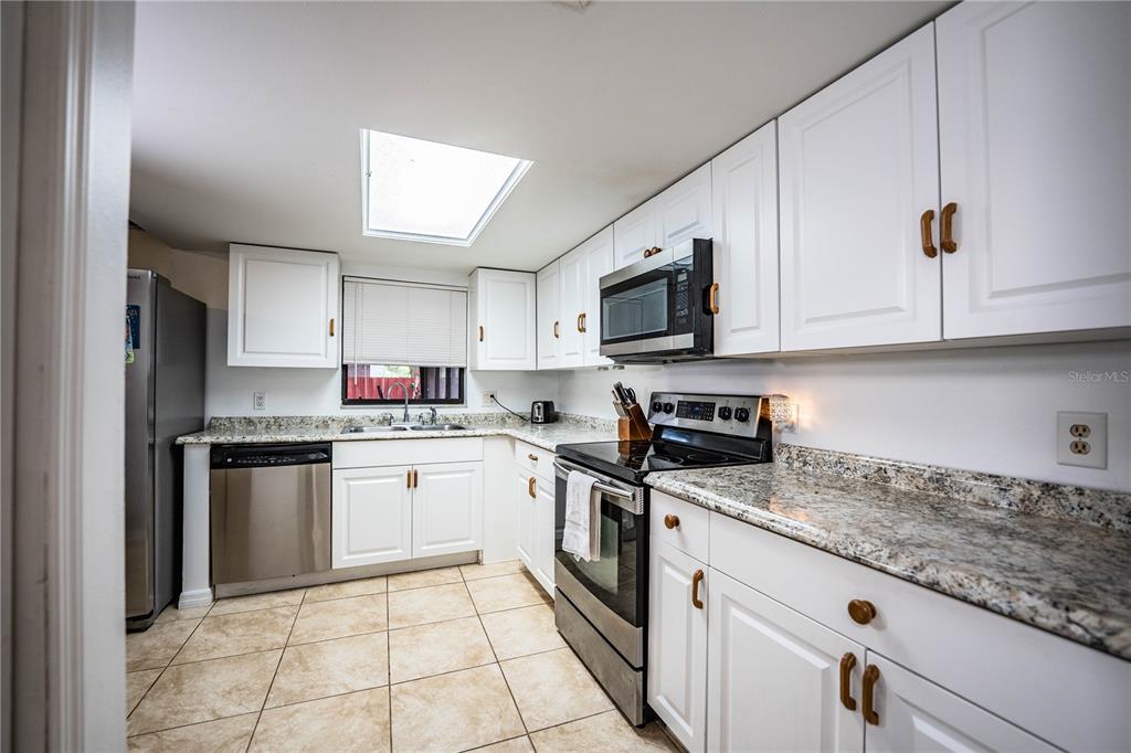 207 24th Court Southwest Winter Haven, FL 33880 - Photo 17 of 75 a kitchen with granite countertop white cabinets stainless steel appliances and a counter space