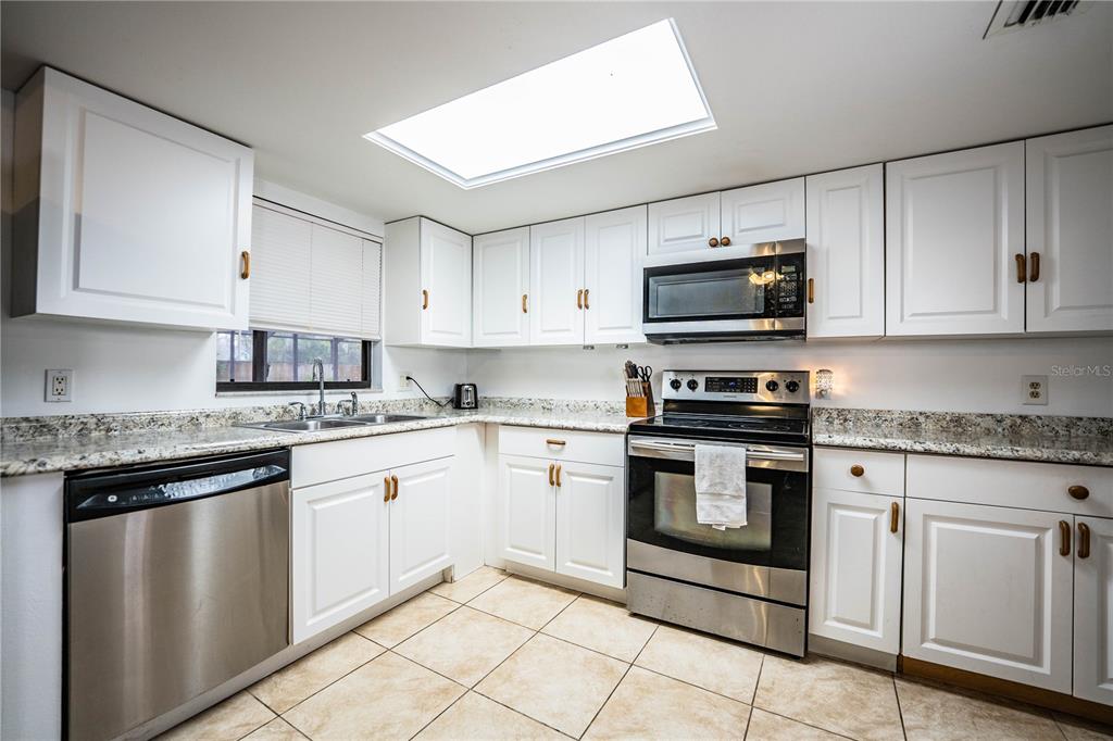 207 24th Court Southwest Winter Haven, FL 33880 - Photo 20 of 75 a kitchen with granite countertop white cabinets and stainless steel appliances