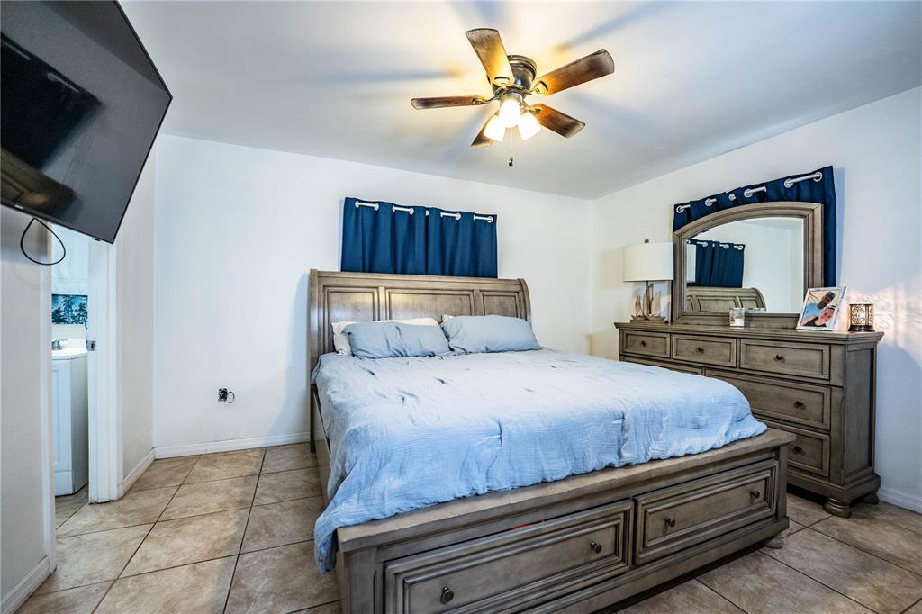 207 24th Court Southwest Winter Haven, FL 33880 - Photo 24 of 75 a bedroom with a large bed and a flat tv screen on a dresser
