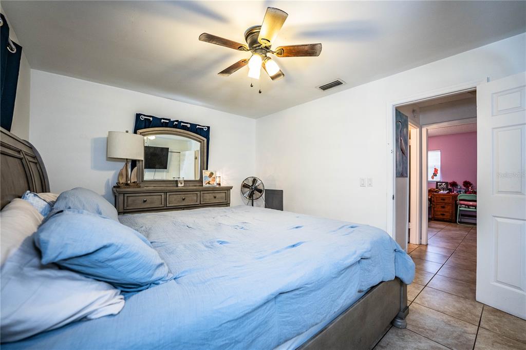 207 24th Court Southwest Winter Haven, FL 33880 - Photo 27 of 75 a spacious bedroom with a bed and a chandelier