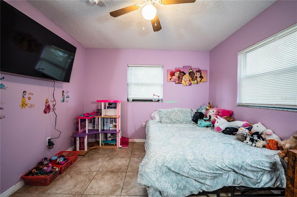 207 24th Court Southwest Winter Haven, FL 33880 - Photo 32 of 75 a bedroom with a bed and a flat screen tv